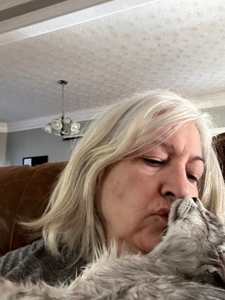 Breeder giving kitten a kiss - Majesti Maine Coon Cats